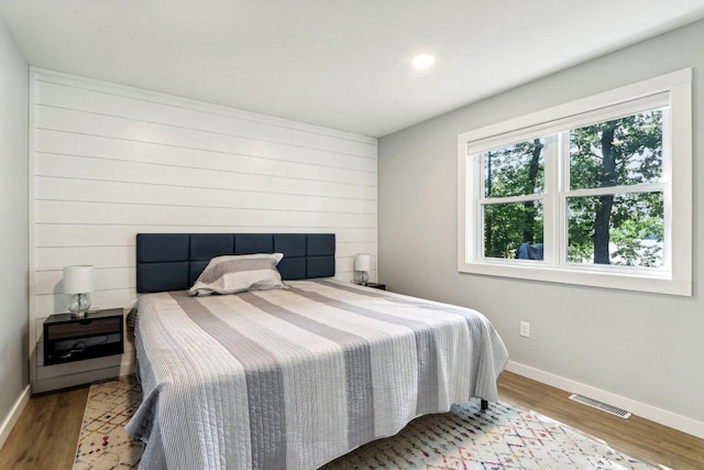 bedroom featuring visible vents, baseboards, and wood finished floors