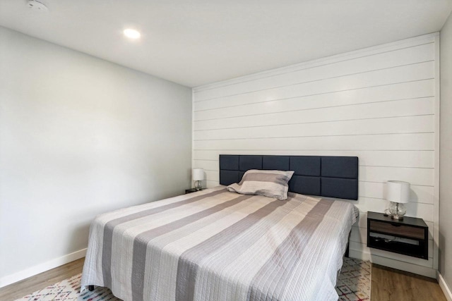 bedroom with baseboards and wood finished floors