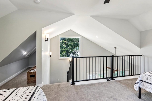 carpeted bedroom featuring baseboards and vaulted ceiling