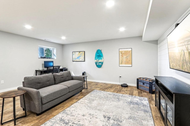 living area with baseboards, recessed lighting, and wood finished floors