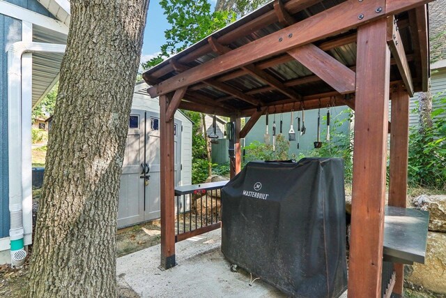 view of patio featuring a grill, an outbuilding, and a storage unit