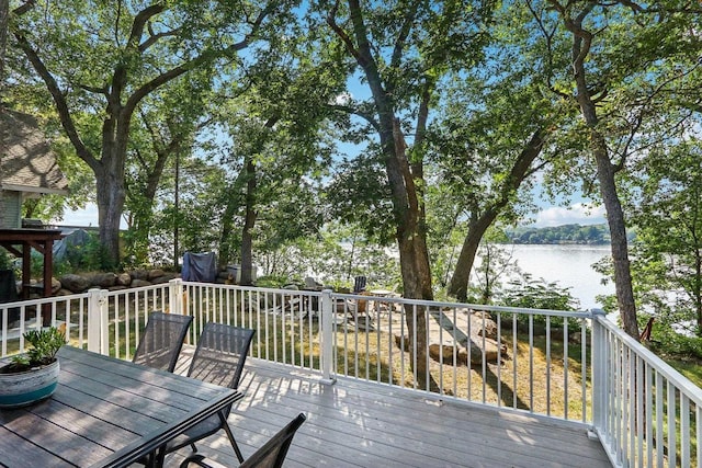 wooden terrace featuring a water view and outdoor dining area