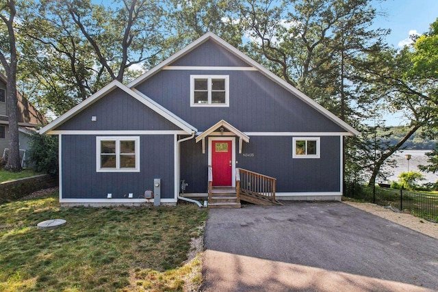 chalet / cabin featuring a front yard, entry steps, and fence
