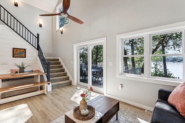 living area with stairway, wood finished floors, visible vents, and a wealth of natural light