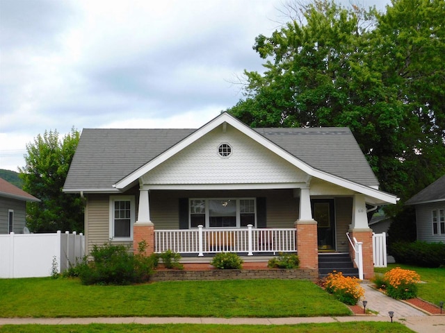 craftsman-style home featuring covered porch and a front yard