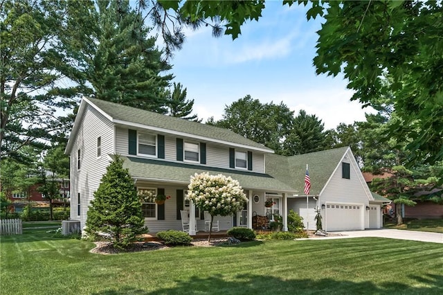 view of front of home with a front lawn, cooling unit, covered porch, and a garage