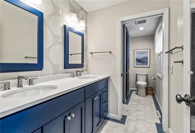 bathroom featuring toilet, vanity, and tile patterned flooring