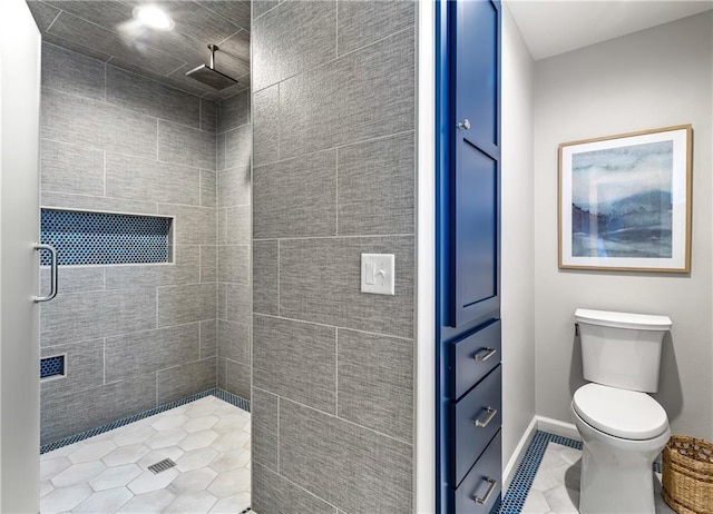 bathroom with toilet and a tile shower