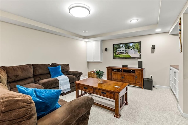 carpeted living room with a tray ceiling