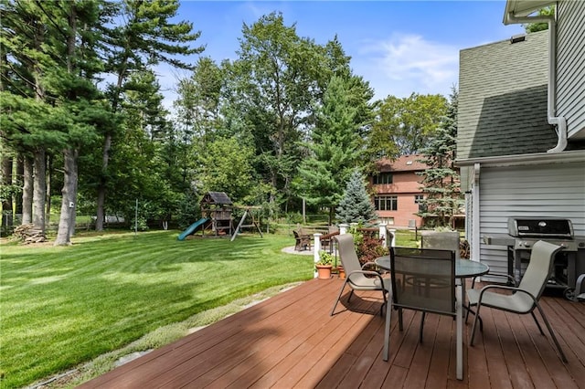 deck with a playground, a lawn, and area for grilling