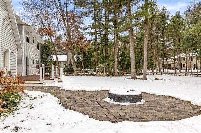 yard layered in snow featuring an outdoor fire pit