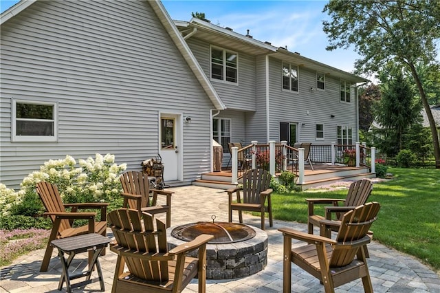 rear view of house with a patio area, a deck, a fire pit, and a lawn