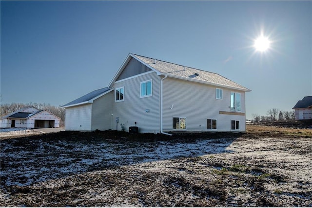 back of property featuring central air condition unit and a garage