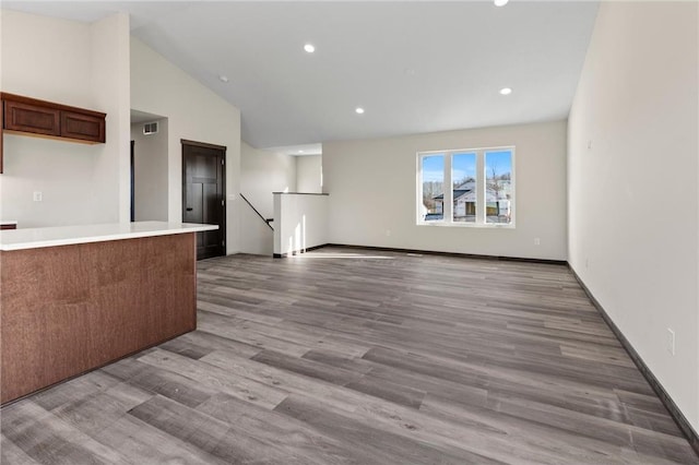 kitchen featuring light wood-type flooring and high vaulted ceiling