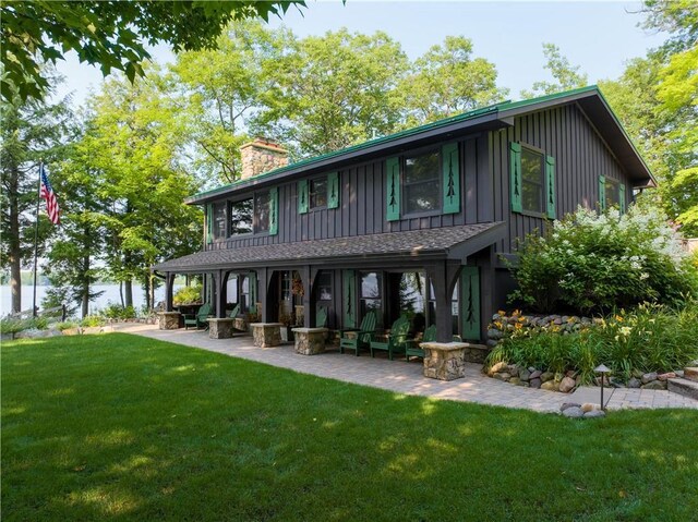 rear view of property featuring a yard and a patio area