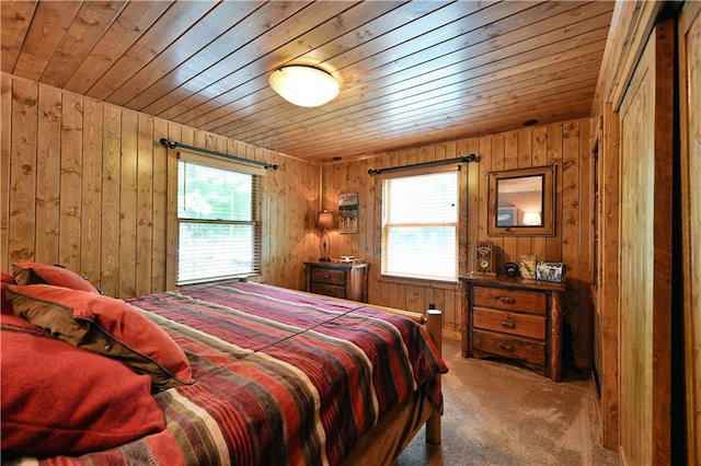 bedroom featuring multiple windows, wood ceiling, wooden walls, and carpet flooring