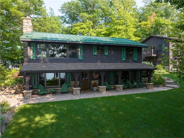 rear view of house with a patio area and a lawn