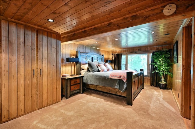 bedroom featuring light colored carpet, wooden walls, and wooden ceiling