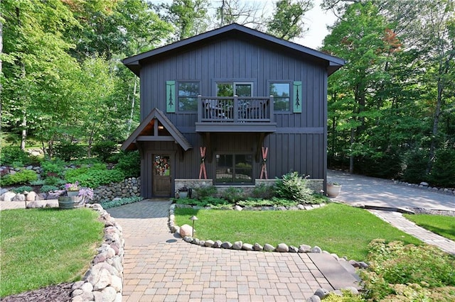 view of front of house with a front yard and a balcony