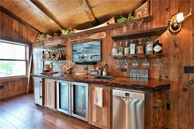 bar with wood walls, lofted ceiling with beams, sink, stainless steel dishwasher, and wood ceiling