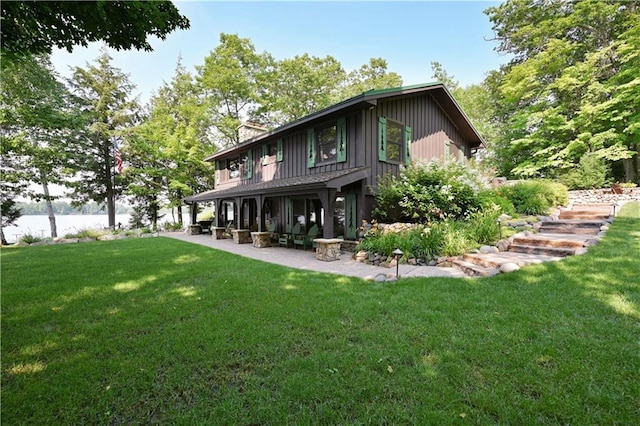 back of property with a patio and a yard