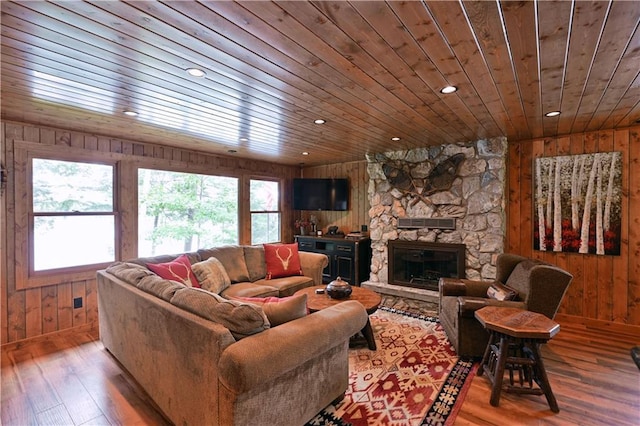 living room with wood ceiling, a fireplace, hardwood / wood-style flooring, and wood walls