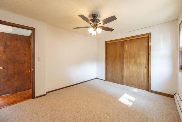 unfurnished bedroom featuring a textured ceiling, parquet flooring, ceiling fan, baseboard heating, and a closet