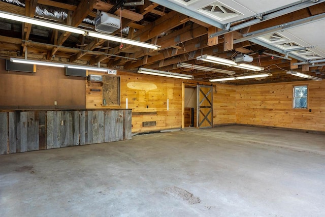 garage featuring a garage door opener and wooden walls