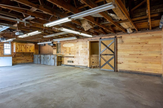 interior space featuring a garage door opener and wooden walls