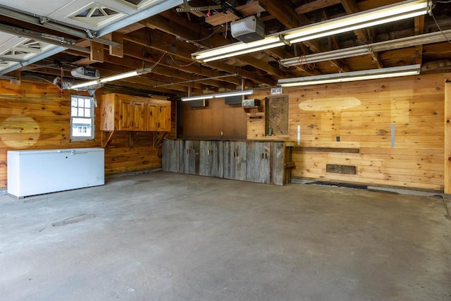 garage with wood walls and a garage door opener