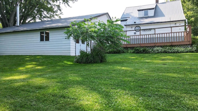 rear view of property featuring a yard and a wooden deck