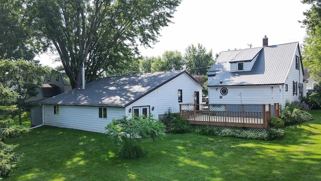 rear view of property featuring a deck and a lawn