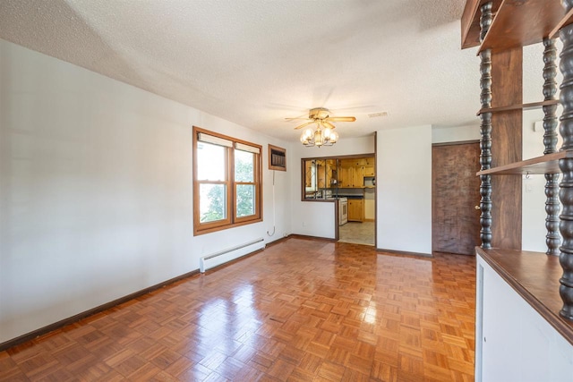 unfurnished living room with ceiling fan, a baseboard heating unit, parquet flooring, and a textured ceiling