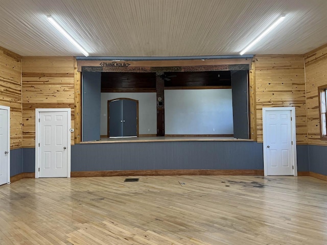 empty room featuring hardwood / wood-style flooring and wood walls