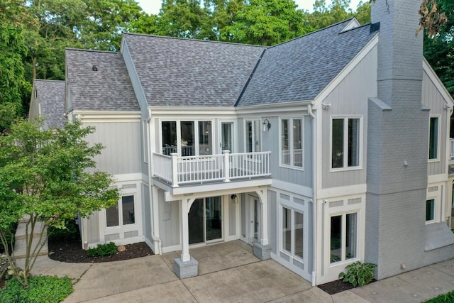 rear view of property featuring a patio and a balcony