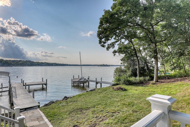 dock area with a water view and a yard