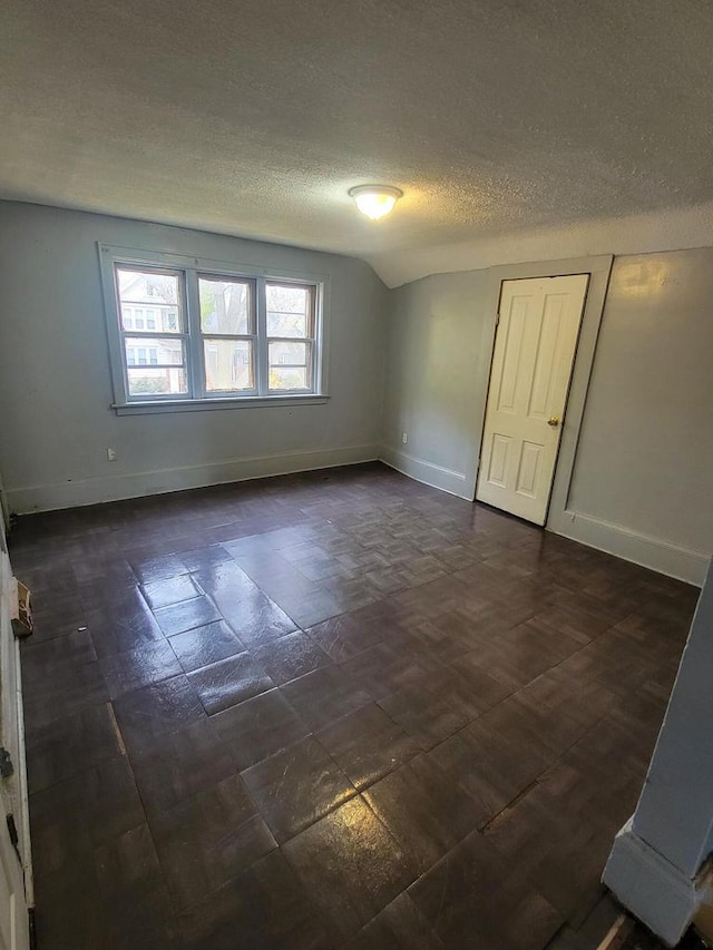 empty room featuring lofted ceiling and a textured ceiling