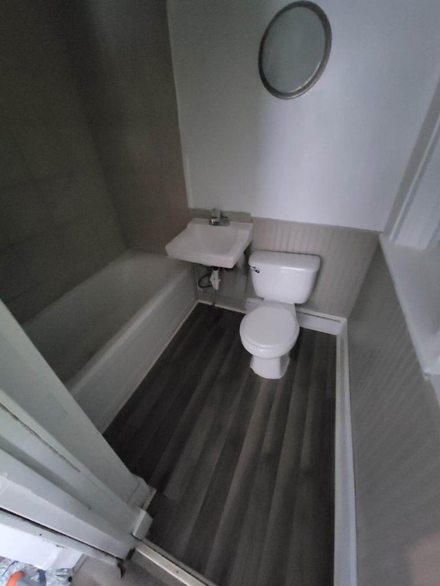 bathroom with hardwood / wood-style flooring, toilet, and sink