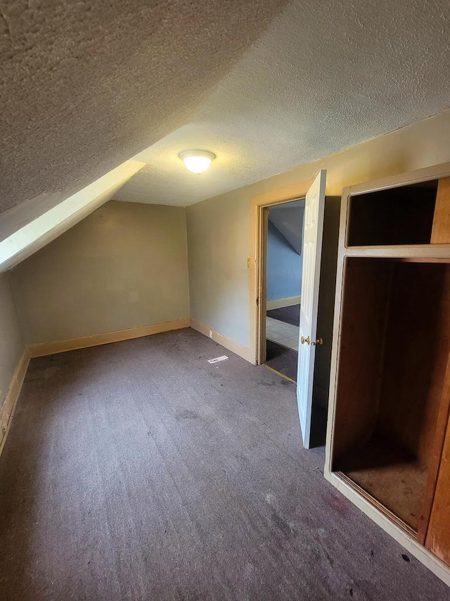 bonus room with carpet floors and a textured ceiling