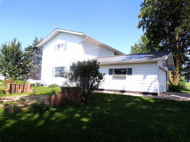 view of home's exterior with a garage and a yard