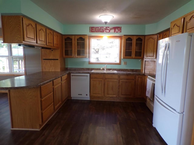 kitchen with white appliances, dark hardwood / wood-style flooring, sink, and kitchen peninsula