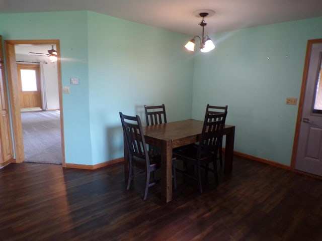 dining room with ceiling fan with notable chandelier and dark wood-type flooring