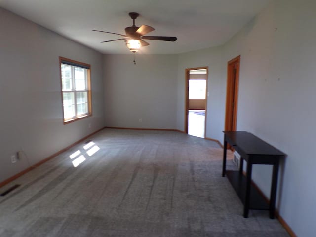 carpeted spare room featuring ceiling fan