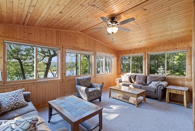 carpeted living room with ceiling fan, wood walls, vaulted ceiling, and wooden ceiling