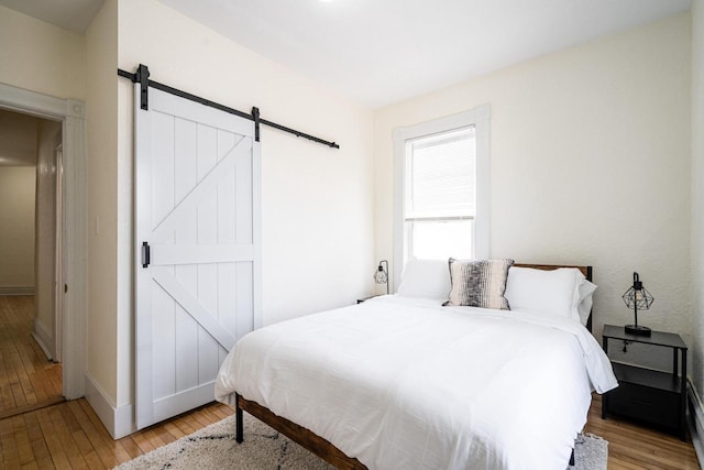 bedroom featuring light hardwood / wood-style flooring and a barn door