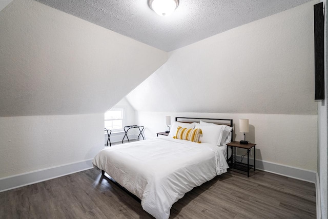 bedroom featuring lofted ceiling, dark hardwood / wood-style floors, and a textured ceiling