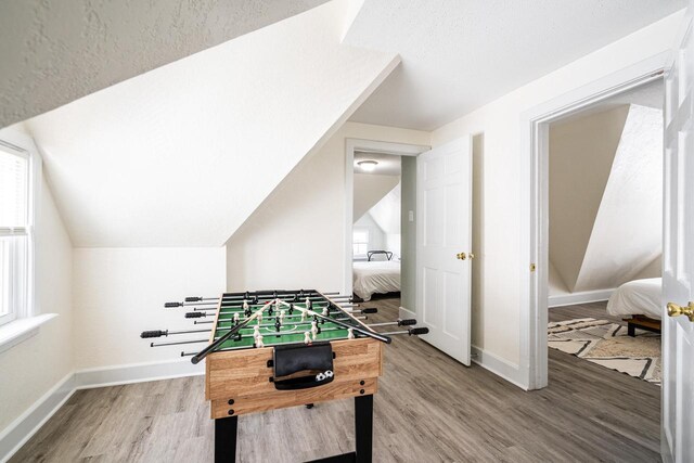 game room featuring wood-type flooring and lofted ceiling