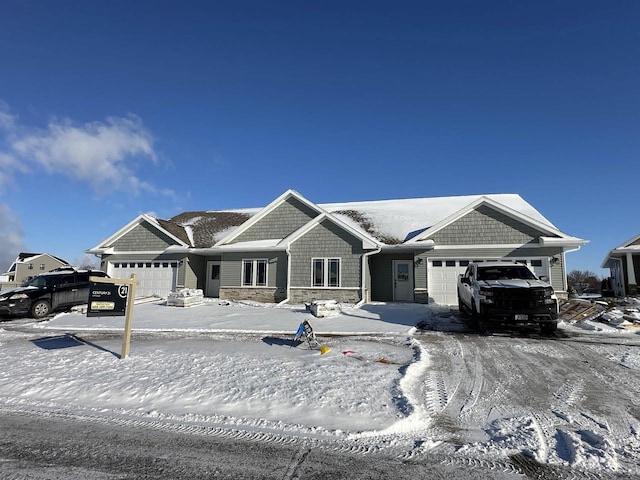 view of front of property featuring a garage and stone siding