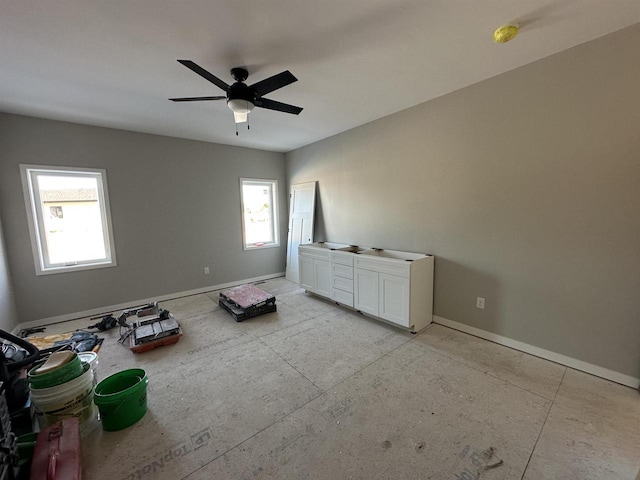 spare room with ceiling fan and baseboards