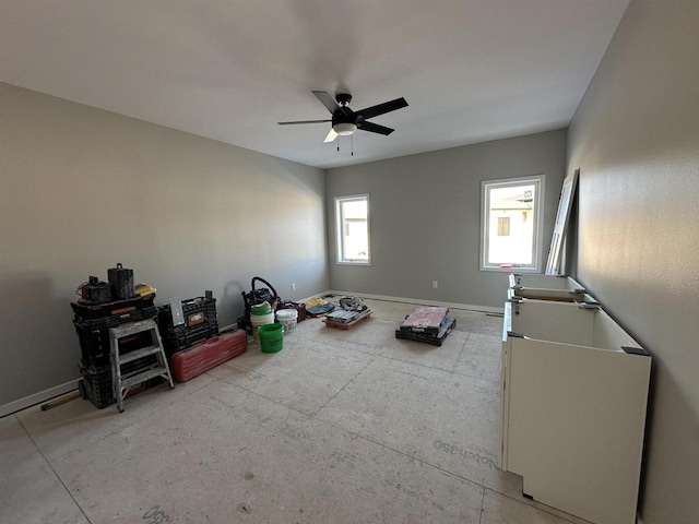 interior space featuring baseboards and a ceiling fan